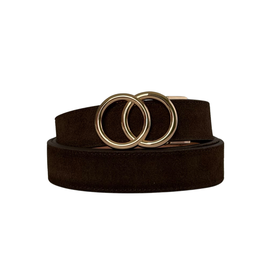 A dark brown suede belt with a unique interlocking double-ring gold-tone buckle, coiled on a plain white background.