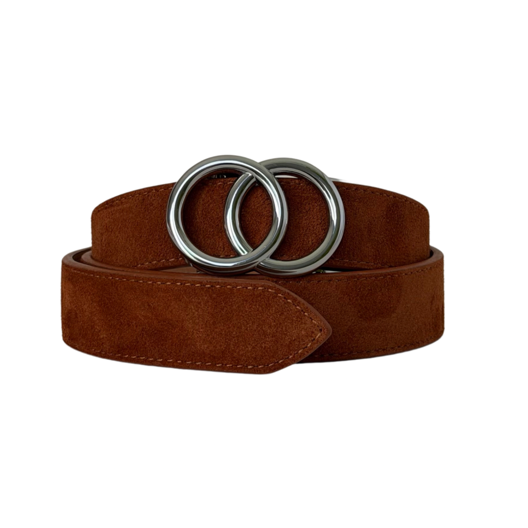 A brown suede belt with a large, polished silver-tone double-ring buckle, neatly coiled on a solid white background.